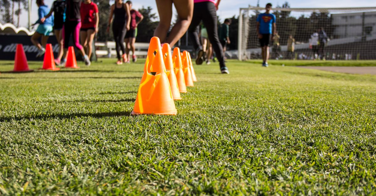 Youth football training session with cones and players practicing passing drills