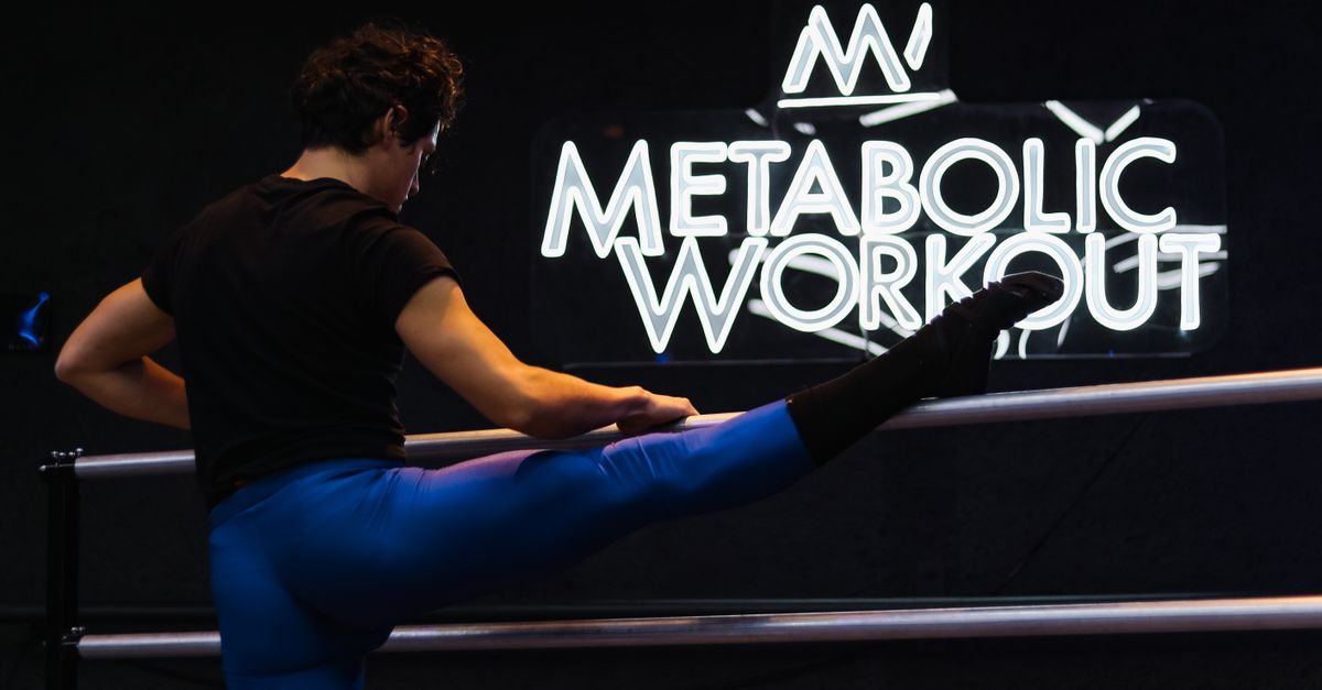 Athlete performing a hip mobility stretch on a mat before training