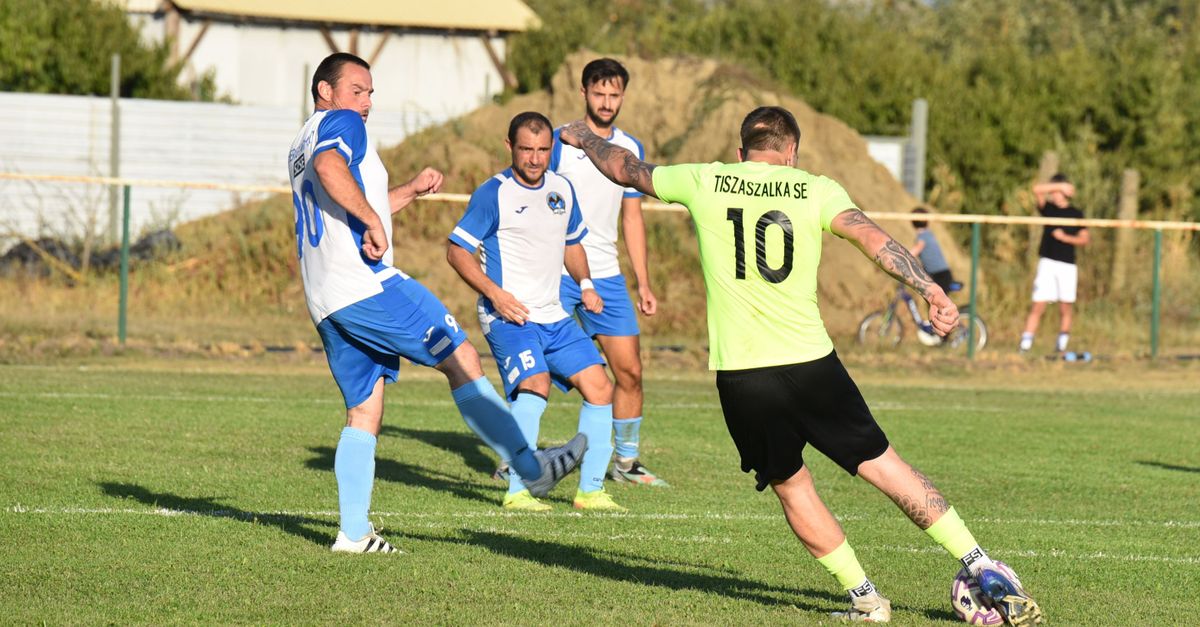Amateur football players contesting the ball on a grass pitch during a weekend match