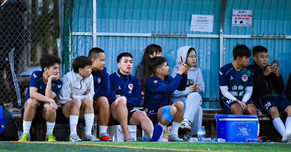 Coach speaking with young players on the sideline of a neighborhood football field