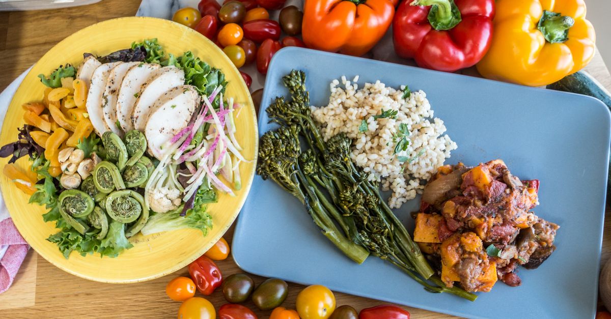 Simple meal with grains, vegetables and water arranged on a kitchen table